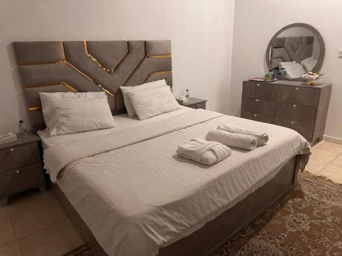 a bedroom with a large bed with two towels on it at شقق ارجان نجد المفروشه in Al Nairyah