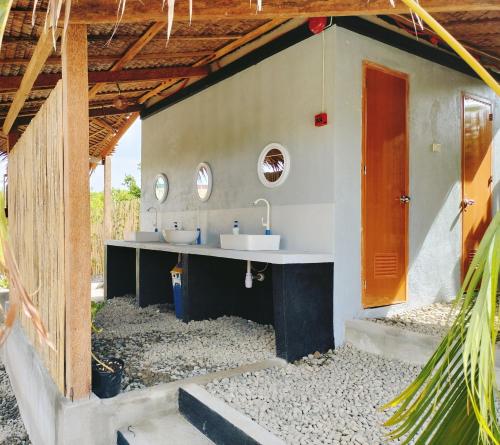 a bathroom with two sinks in a house at Riu del Mar Hostel in Dauis