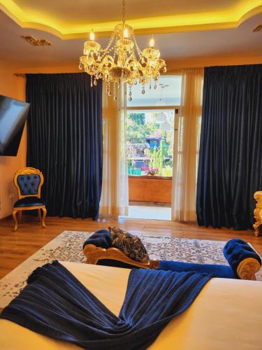 a bedroom with a large bed with a chandelier at Luxury Mansion Sant Serrant Cerca Aeropuerto Medellín Guatapé in Marinilla