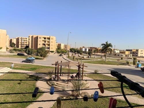 a park with a playground in a city with buildings at شقه مفروشه فرش فندقي بمدينه العبور الحي الراقي فيو حديقه in ‘Ezbet el-Insha