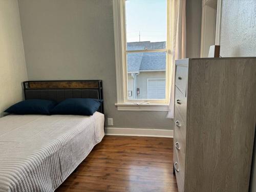 ein Schlafzimmer mit einem Bett, einem Fenster und einer Kommode in der Unterkunft Spacious Downtown Home SJ in San Jose