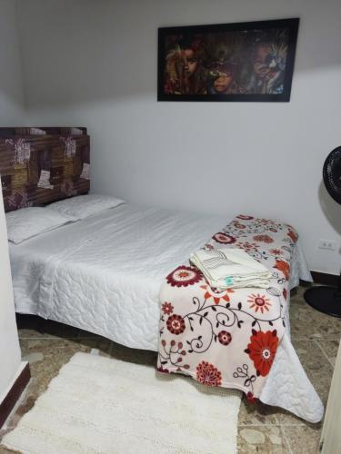 1 dormitorio con 1 cama con manta roja y blanca en Apartamentos cerca ala basílica, en Buga