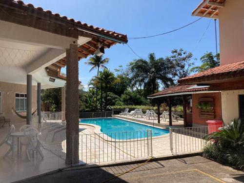 a villa with a swimming pool and a house at Pousada Vale das Flores in Penedo