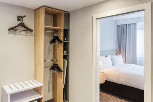 a hotel room with a bed and a mirror at Holiday Inn Express Dresden Zentrum by IHG in Dresden