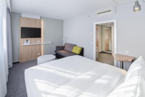 Habitación de hotel con cama y sofá en Holiday Inn Express Dresden Zentrum, an IHG Hotel, en Dresden