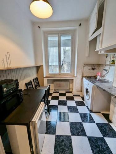 - une cuisine avec un sol en damier noir et blanc dans l'établissement *Très beau T2 en plein Hypercentre, à Grenoble
