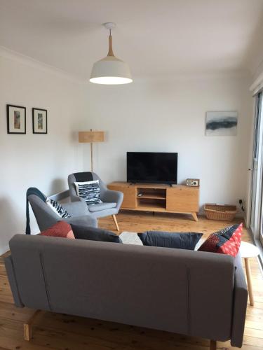 Una sala de estar con un sofá y un televisor. en Lago, en Manyana
