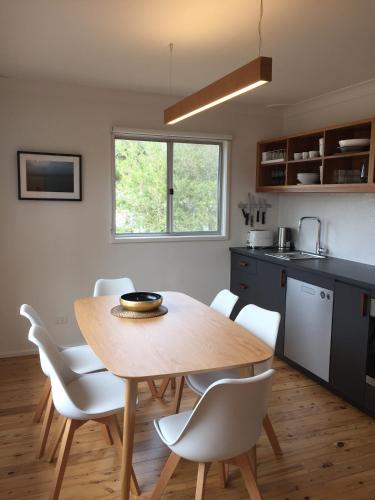 Una cocina y un comedor con mesa y sillas de madera. en Lago, en Manyana