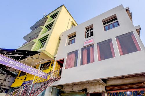 a tall white building with red and yellow windows at SPOT ON City Lodge Ganeshguri in Dispur