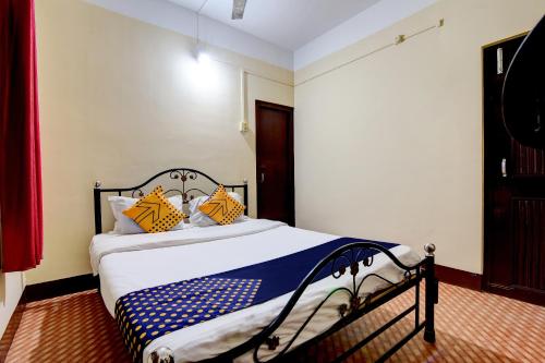 a bedroom with a bed with yellow and blue pillows at SPOT ON City Lodge Ganeshguri in Dispur
