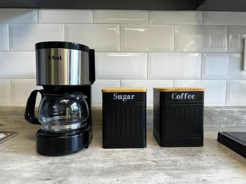 a coffee maker and two trash cans on a kitchen counter at La Terraza Home in Guadalajara