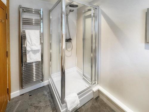 a shower with a glass door in a bathroom at Castleriggs Cottage - Uk45178 in Threlkeld
