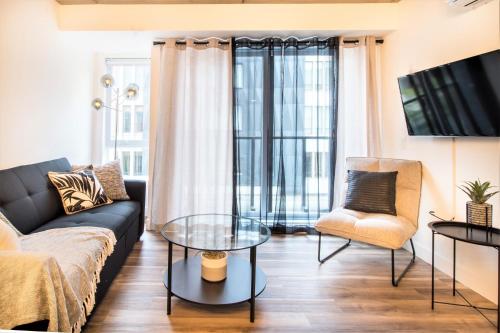 a living room with a couch and a glass table at Condo moderne, centre-ville piscine, terrasse, gym in Quebec City