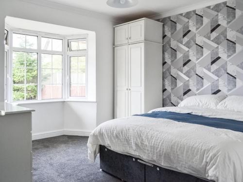 a bedroom with a large bed with a geometric headboard at Sunny Bungalow in Chapel Saint Leonards