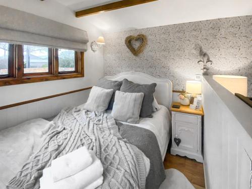 a bedroom with a large bed with pillows at Little Norfolk Cabin in Neatishead