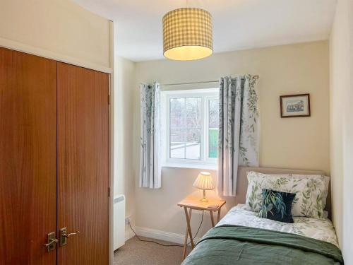 een slaapkamer met een bed en een raam bij Half Moon Cottage in Brafferton