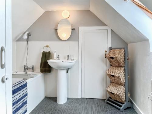 a bathroom with a sink and a mirror and a door at Yardie View in Buckie