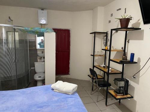 a bedroom with a bed and a shower and a toilet at Habitación privada Leonera in Cholula