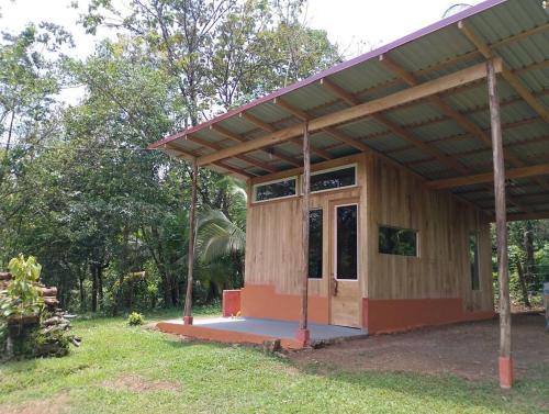 ein kleines Holzgebäude mit einer Tür im Hof in der Unterkunft Cabina Gooder in Chachagua
