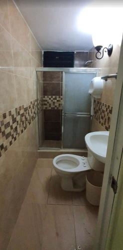 a bathroom with a toilet and a sink at Casa hotel apartamento in Santiago de los Caballeros