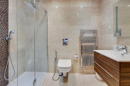 uma casa de banho com um chuveiro, um WC e um lavatório. em Marylebone - MCR Residences em Londres