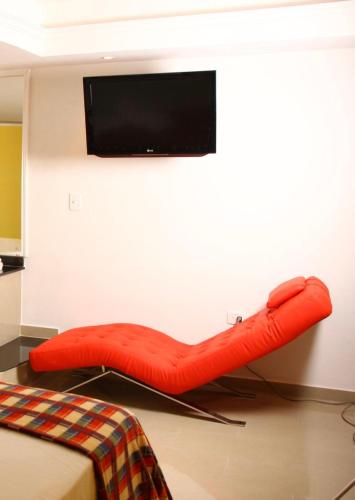 a red bean bag chair in a room with a tv at Casa hotel apartamento in Santiago de los Caballeros