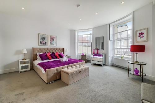 um quarto com uma cama grande e lençóis roxos em Marylebone - MCR Residences em Londres
