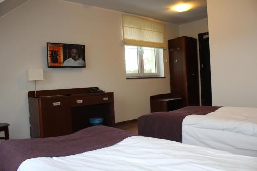 a hotel room with two beds and a window at Hotel Marusza in Grudziądz