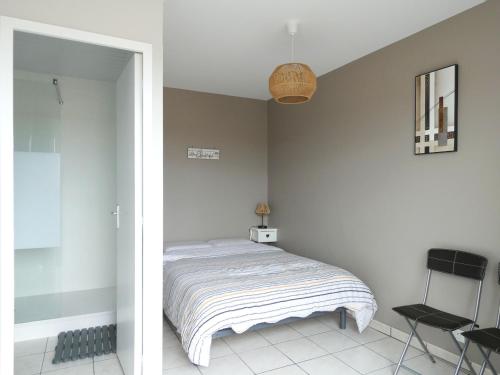 une chambre avec un lit et une chaise dedans dans l'établissement Appartement rénové à Saint-Hilaire-de-Riez, parking privé, proche plage et commerces - FR-1-323-258, à Saint-Hilaire-de-Riez