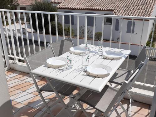 une table blanche et des chaises sur un balcon dans l'établissement Appartement 1er étage proche centre-ville, plage et commerces, balcon, parking, WIFI inclus - FR-1-22-171, à La Tranche-sur-Mer