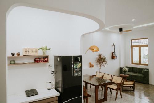 eine Küche und ein Esszimmer mit einem schwarzen Kühlschrank und einem Tisch in der Unterkunft Nagi cottage in Kinh Dinh