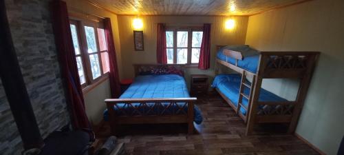 a small room with two bunk beds and two windows at alojamientos CM in Tolhuin
