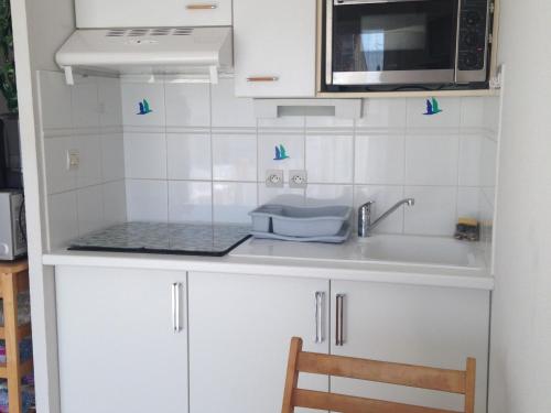 a kitchen with a sink and a microwave at Appartement près de la plage - 4 pers, piscine ouverte, parking, animaux acceptés - FR-1-706-12 in Châtelaillon-Plage