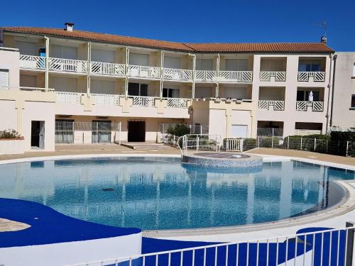 une grande piscine devant un immeuble dans l'établissement Appartement près de la plage - 4 pers, piscine ouverte, parking, animaux acceptés - FR-1-706-12, à Châtelaillon-Plage