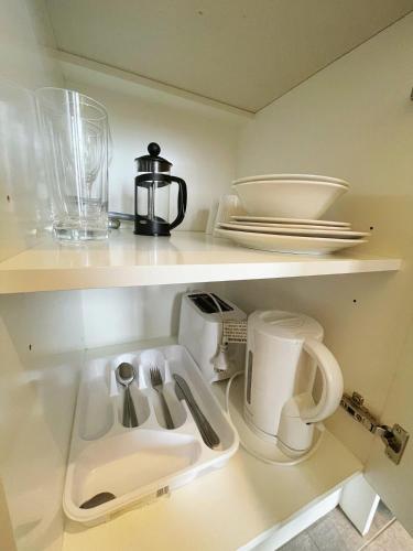 a kitchen shelf with a sink and a coffee maker at Grand Central Serviced Apartments in Auckland