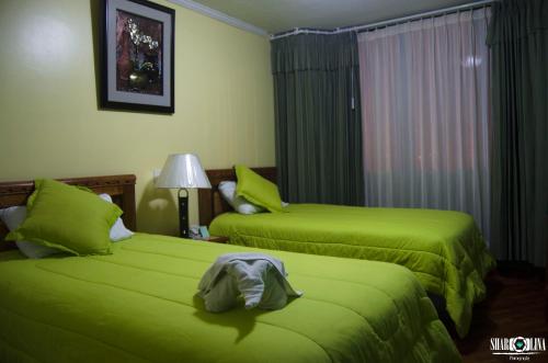 2 camas de color verde lima en una habitación de hotel en Hotel San Andrés, en San Andrés