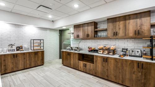 a large kitchen with wooden cabinets and appliances at Holiday Inn Dallas Market Ctr Love Field by IHG in Dallas