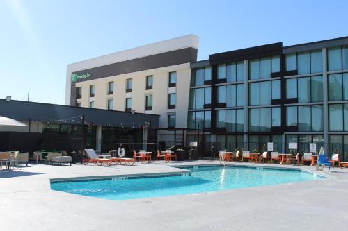 a building with a swimming pool in front of a building at Holiday Inn Dallas Market Ctr Love Field by IHG in Dallas
