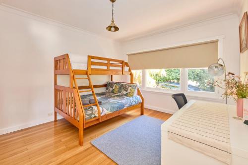 a bedroom with a bunk bed and a desk at Basin Road Townhouse in Royal Park