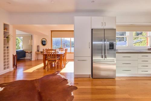 a kitchen and a dining room with a table at Basin Road Guesthouse in Royal Park