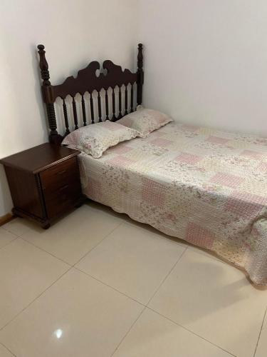 a bedroom with a bed and a wooden nightstand at Chambre Achada São Filipe, Praia in Praia