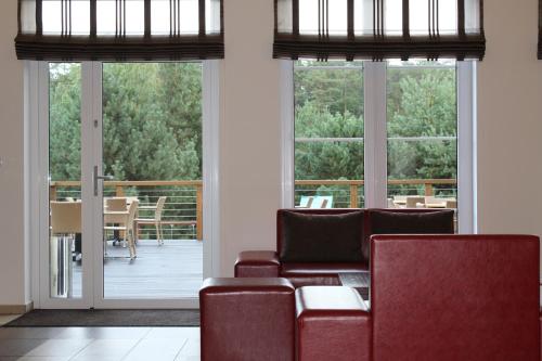 a living room with a couch and chairs and windows at Hotel Marusza in Grudziądz