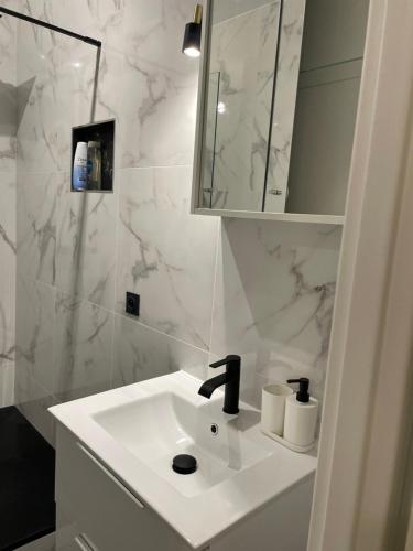 bagno bianco con lavandino e specchio di Jana holiday ad Arcueil