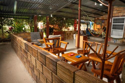 grupa drewnianych krzeseł i stół na patio w obiekcie Posada Campestre Ecoturística Granja Julieth w San José Del Guaviare