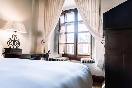 a bedroom with a bed and a large window at Quinta Real Oaxaca in Oaxaca City