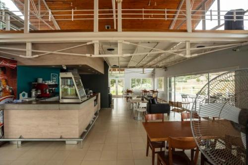 a restaurant with a counter and tables and chairs at Condominio Monte Molinos - dpto vista al lago - por RENT Lago Los Molinos in Villa Ciudad de America