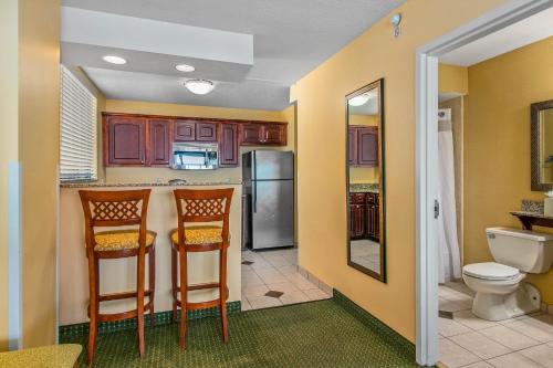a kitchen with two chairs and a refrigerator at Holiday Inn & Suites Clearwater Beach, an IHG Hotel in Clearwater Beach
