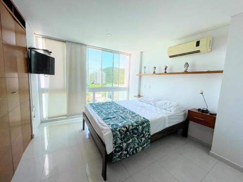 1 dormitorio con cama y ventana grande en Apartamento con vista al mar en Santa Marta, en Santa Marta