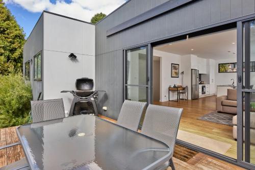 a house with a glass table and chairs at The Gorge Townhouse, stunning home & location! in Royal Park