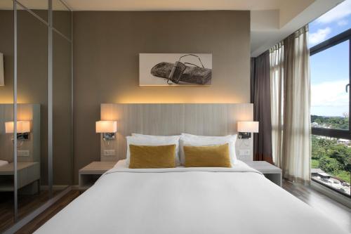 A bed or beds in a room at Citadines Uplands Kuching